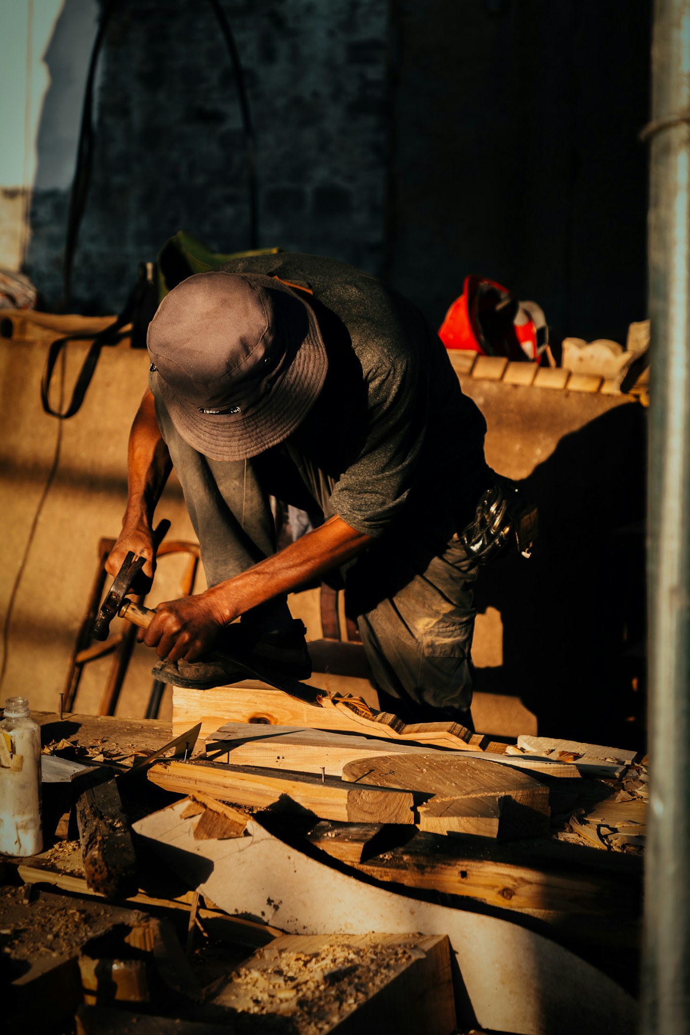 A carpenter shaping wood with a hand tool in a workshop